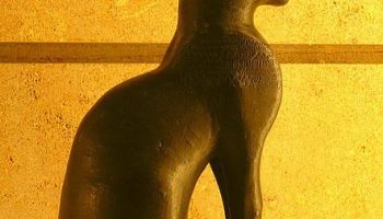 A Black Egyptian statue against a yellow background.