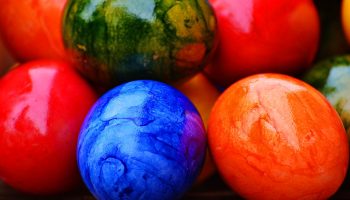 A colorful mix of colored eggs are presented. Colors such as blue, orange, red and green are shown.